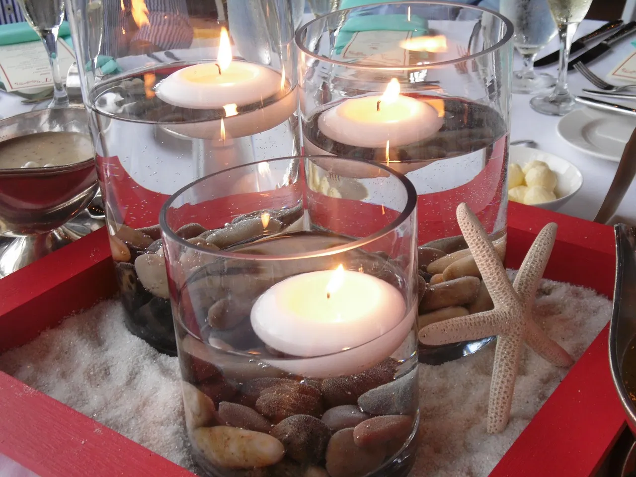 Long reception table set with candles and glassware at dusk