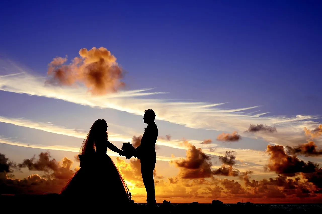 Silhouette of a couple embracing against a dramatic sunset sky